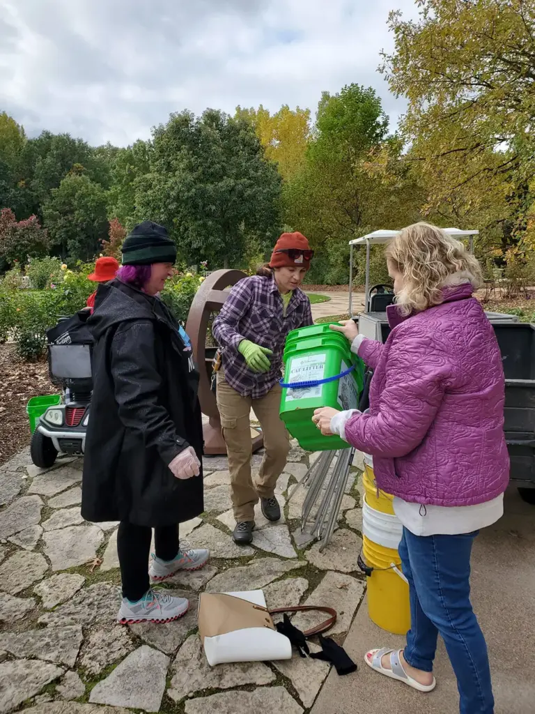 3 people volunteering at the Green Bay Botanical Gardens for a service trip