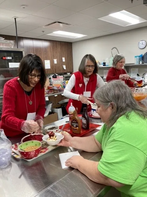 Volunteers serving lunch to guests at Wellspring