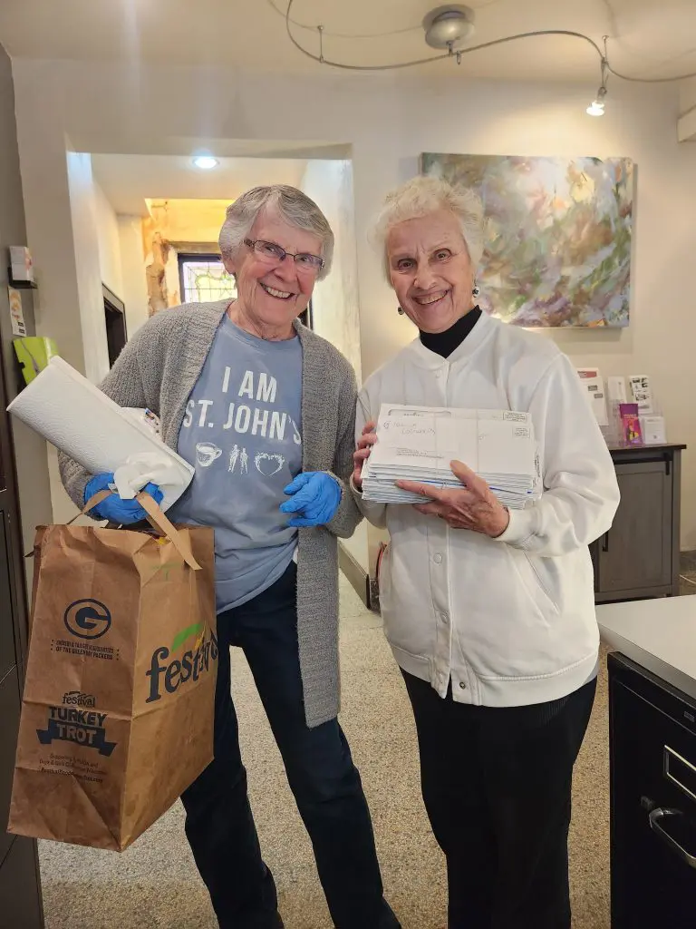 two volunteers smiling 